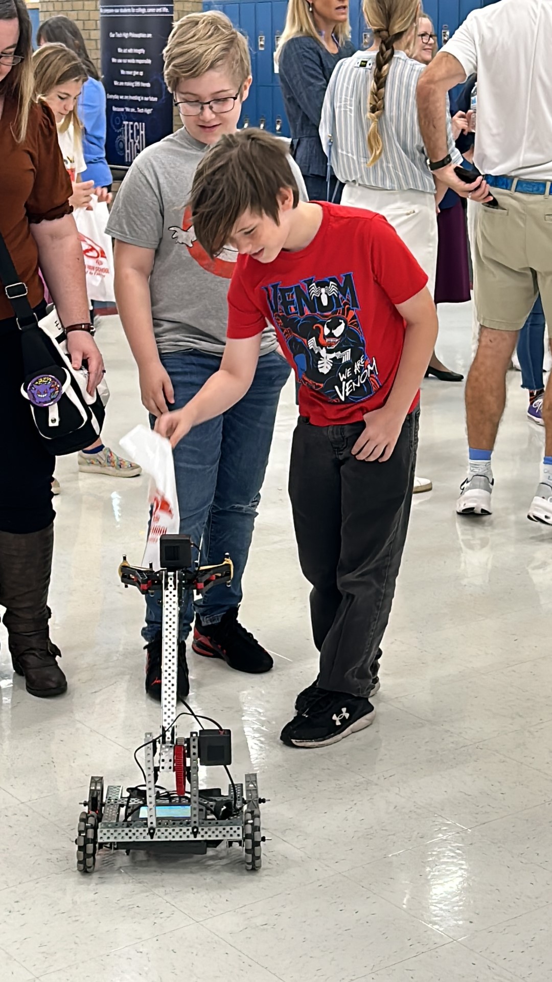 A child looking at a robotDescription automatically generated